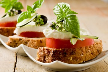 Tartine di pomodoro e mozzarella su letto di pane ai cereali