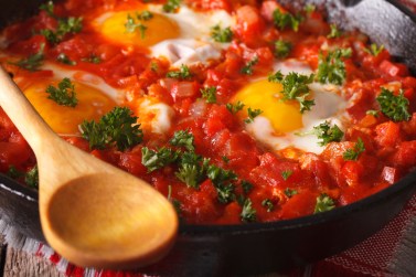 Breakfast shakshuka fried eggs with tomato sauce macro. horizontal
